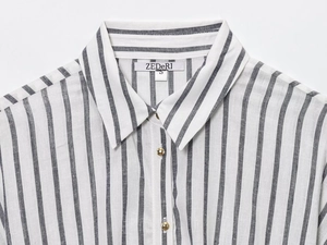 Primo piano del colletto di camicia a righe in lino con bottoni dorati e trama