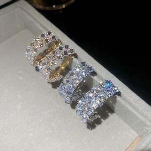 Macro shot of silver and gold C-shaped earrings with sparkling cubic zirconia rows