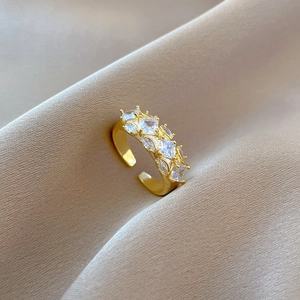Detailed view of adjustable gold ring with square cubic zirconia on silk fabric