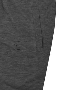 Detailed close-up of dark grey knit fabric featuring side pocket and distressed hole design