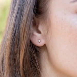 Macro detail of star-shaped S925 sterling silver stud earrings featuring cubic zirconia