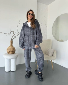 Détail d'un ensemble hoodie tie-dye gris avec poignets élastiques et coton à fermeture