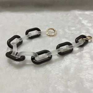 Close-up of brown acrylic chunky chain with gold spring ring clasps on plush background