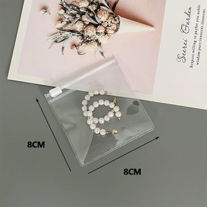 Transparent PVC storage pouch with white pearl hoop earrings, measuring 8cm x 8cm size