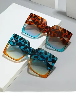 Detail view of square leopard print sunglasses with gradient lenses on white props