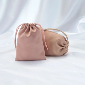 Detail of soft pink satin drawstring pouches for jewelry with silky textured surface
