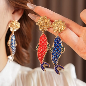 Detailed close-up of vintage koi fish earrings in red and blue enamel with rhinestones