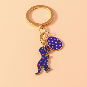 Detailed close-up of a blue enamel dinosaur and egg charm keychain with a gold metal ring