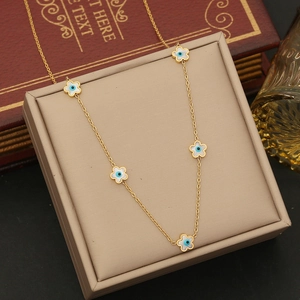 Detail of gold enamel evil eye flower charms on a delicate stainless steel necklace