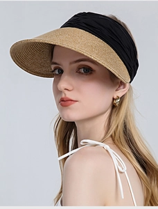 Detail showing the woven straw brim and black pleated fabric crown of the sun hat