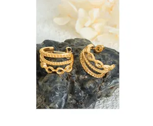 Macro shot of 18K gold plated triple layered C-shape twisted thread earrings on stone