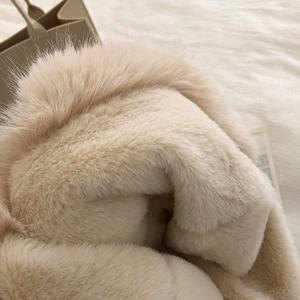 Close-up of beige plush faux fur texture showing soft and fluffy thick material