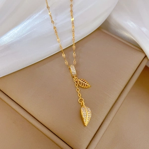 Detail of gold leaf pendants with zircons on silk background and jewelry box