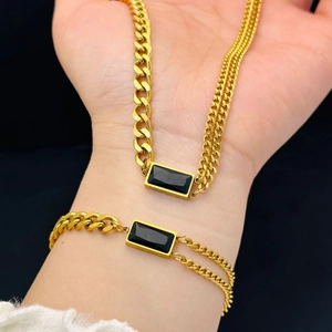 Golden titanium steel jewelry set featuring black square stones on necklace and bracelet