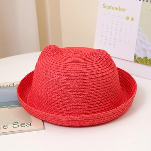 Détail d'un chapeau de paille rouge vif avec des oreilles de chat pour enfants