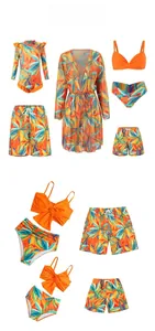 Flat lay of family matching swimwear with orange and blue tropical palm leaf print designs