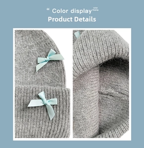 Dettaglio del cappello in maglia grigio con texture morbida e fiocco in nastro blu