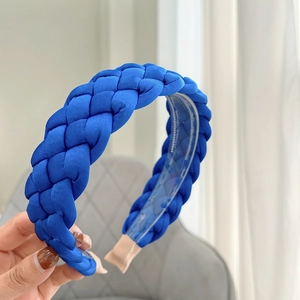 Detail of blue braided fabric headband showing interior plastic teeth and comfort tips