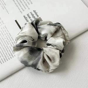 Detailed shot of tie-dye chiffon scrunchie with elegant black and white silk patterns