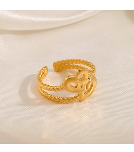 Detailed shot of double heart gold adjustable ring on white silk background texture