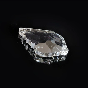 Macro view of transparent faceted crystal ball pendant on a black reflective surface