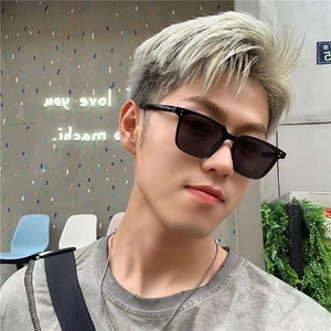 Modern square black sunglasses with metal rivets worn by male model in urban setting