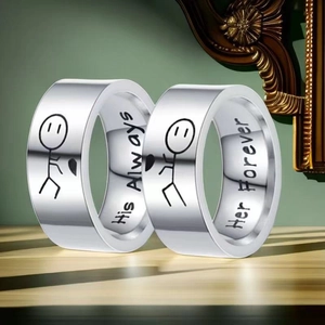 Detail of couple rings with His Always and Her Forever engravings on silver stainless steel