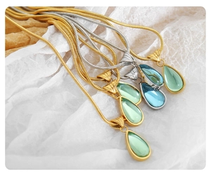 Detailed view of colorful teardrop pendants with gold and silver snake chains