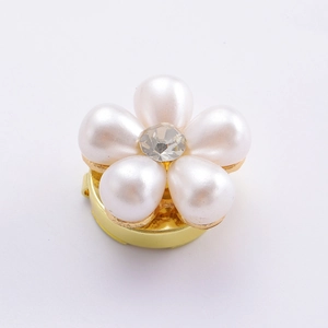 Détail du clip de chemise fleur élégant avec pétales de perles et strass central
