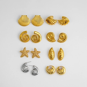 Detail view of 18K gold and silver nautical earrings featuring conch and shell designs