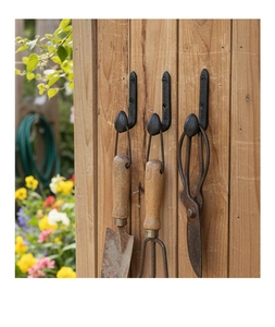 Three heavy-duty black cast iron wall hooks shown with gardening tools on a wood wall