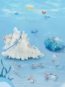 Marine jewelry collection with sea turtle ring and starfish earrings on beach shell decor