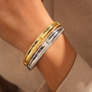 Detail of 18k gold and silver plated bangles with sparkling crystals on a model