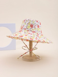 Close-up of floral sun hat with red and yellow flowers and matching tie on a wooden stand