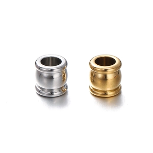 Close-up of polished gold and silver stainless steel cylinder spacer beads for DIY jewelry