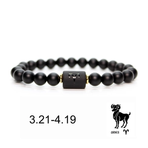 Detail of Aries zodiac elastic bracelet featuring black matte beads and golden accents