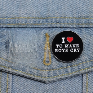 Close-up of black enamel pins with FUTURE MILF and I Love To Make Boys Cry text on denim