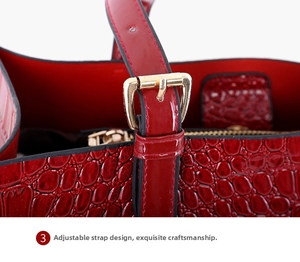 Details einer roten Handtasche mit Krokodilmuster, verstellbarem Griff und Goldschnalle