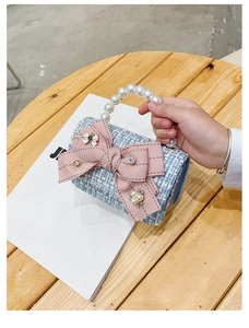 Detail of blue tweed mini purse with pink plaid bow and pearl handle for girls