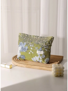 Green floral jacquard cosmetic bag with H&R logo on elegant wooden display stand