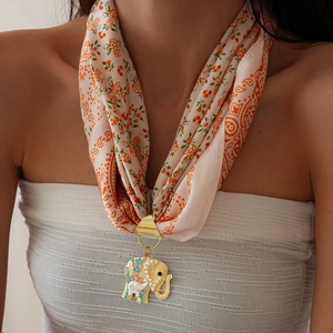 Detail of floral silk scarf with golden elephant pendant and colorful crystal accents
