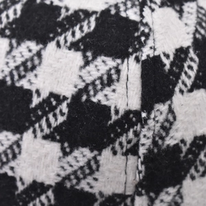 Close-up of thick wool fabric showing high-quality black and white houndstooth pattern weave