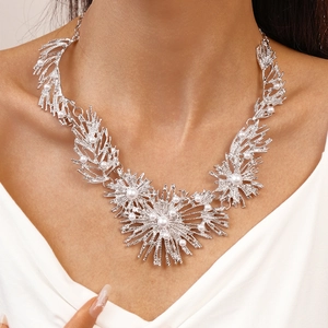 Detail of silver alloy necklace with white pearls in a radial starburst design on model