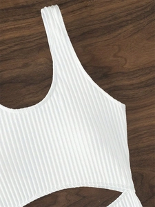 Close-up of white ribbed swimwear fabric showing U-neckline and detailed stitching