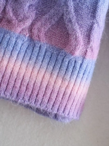Detailed macro view of tie-dye knit texture with purple blue gradient and cable patterns