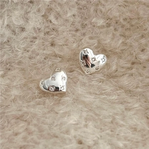 Minimalist 925 sterling silver heart stud earrings with zircon on pink plush background