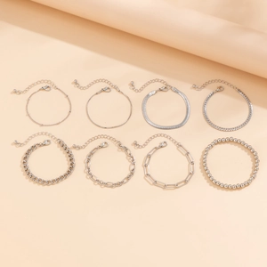 Set of eight silver layered bracelets featuring snake, bead, and paperclip chain links