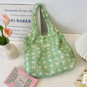 Detail of green floral canvas tote bag featuring Sezakka label and elegant ribbon straps