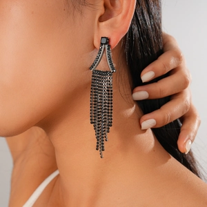 Détail de boucles d'oreilles pendantes à pampilles en strass noirs sur le mannequin