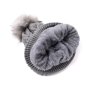 Détail du bonnet en tricot gris avec doublure polaire douce et pompon en fourrure